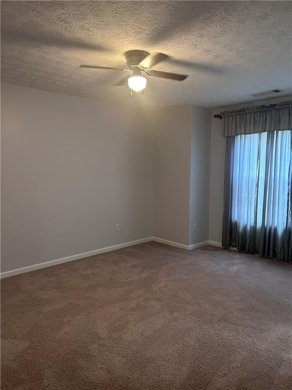 5425 Village Green Sq, Norcross, GA 30093 - empty room featuring ceiling fan, carpet, a textured ceiling, and baseboards