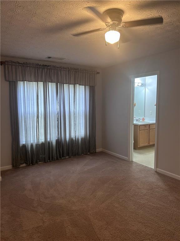 5425 Village Green Sq, Norcross, GA 30093 - carpeted empty room with baseboards, a textured ceiling, and a ceiling fan