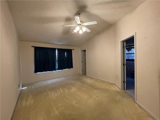 carpeted spare room with ceiling fan, lofted ceiling, and a textured ceiling