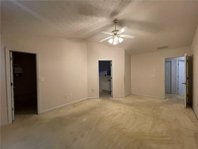 carpeted empty room featuring ceiling fan, lofted ceiling, and a textured ceiling