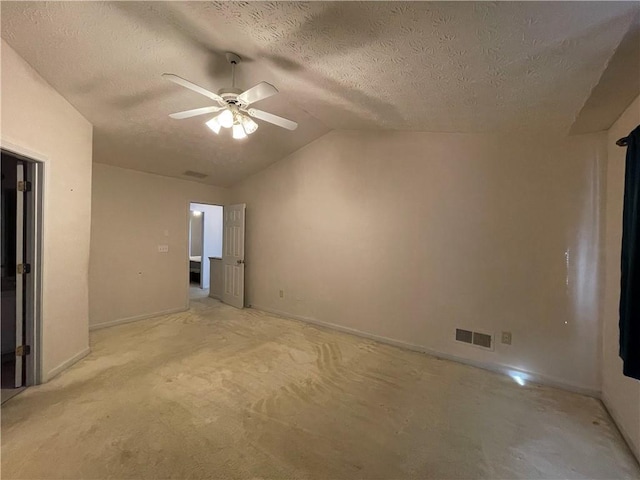 empty room featuring ceiling fan, a textured ceiling, and vaulted ceiling