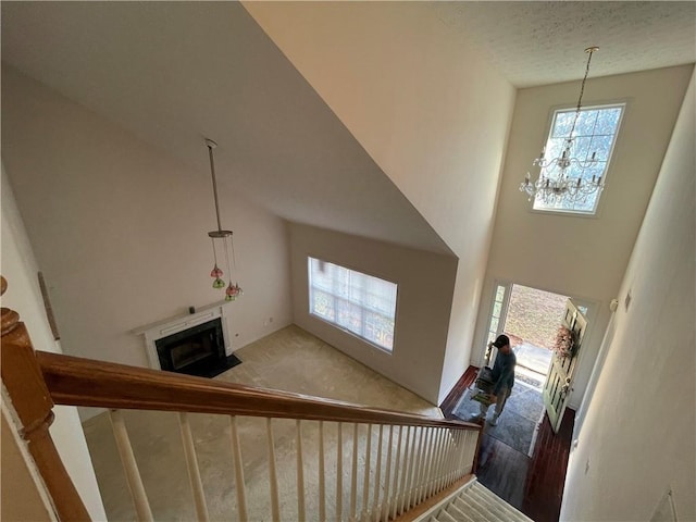 staircase with wood-type flooring, a high ceiling, and an inviting chandelier