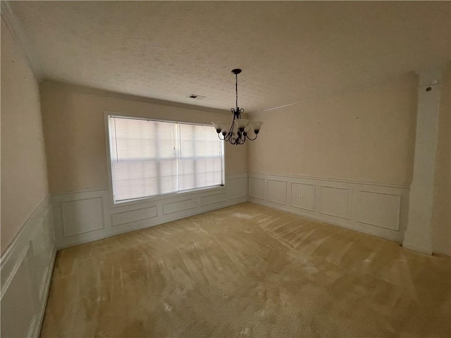 unfurnished dining area featuring light carpet, a textured ceiling, and a notable chandelier