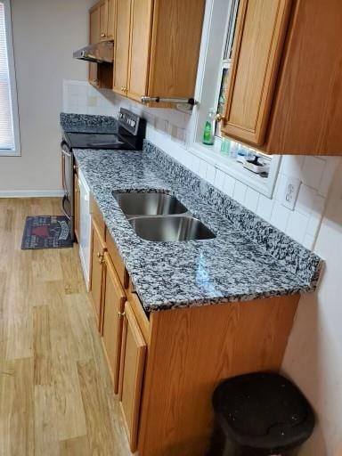 kitchen featuring tasteful backsplash, black range with electric cooktop, ventilation hood, light hardwood / wood-style flooring, and stone counters