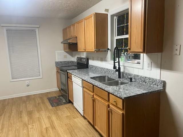 kitchen with white dishwasher, sink, black / electric stove, stone countertops, and light hardwood / wood-style floors