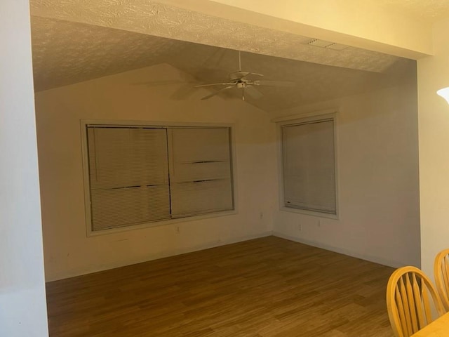 spare room featuring ceiling fan, wood-type flooring, a textured ceiling, and vaulted ceiling