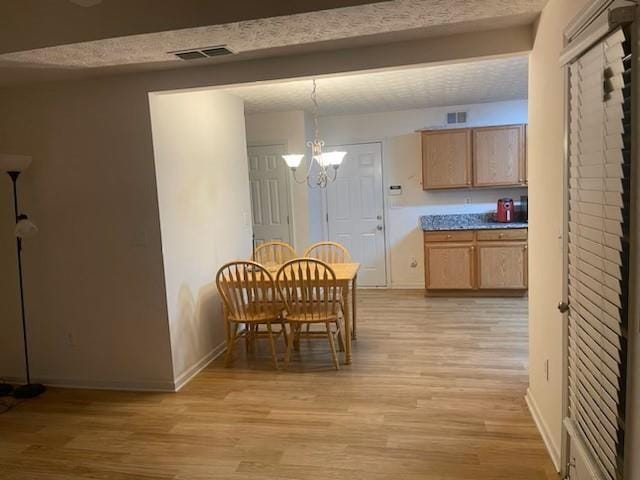 dining room featuring beam ceiling, light wood-type flooring, and an inviting chandelier