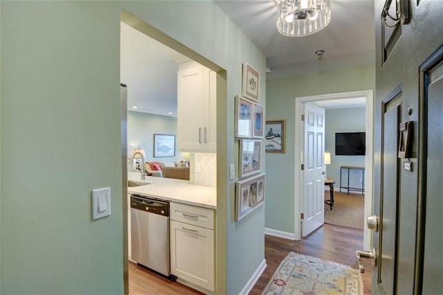 corridor featuring sink, a chandelier, and light hardwood / wood-style flooring