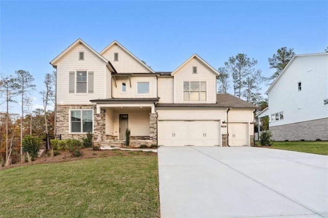 view of front of property with an attached garage, driveway, stone siding, and a front lawn