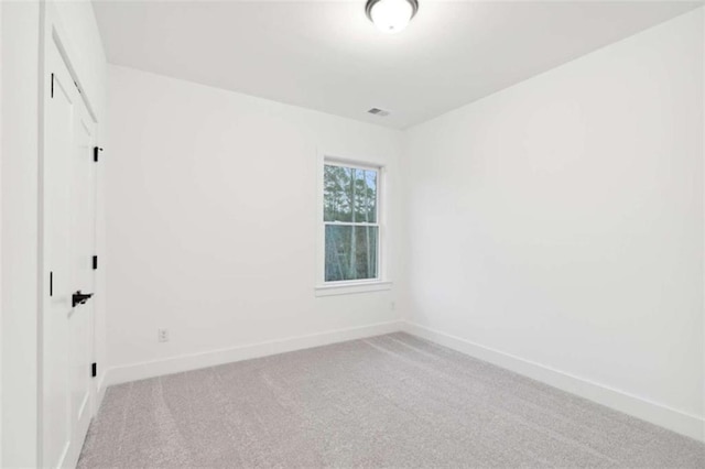 carpeted empty room with visible vents and baseboards