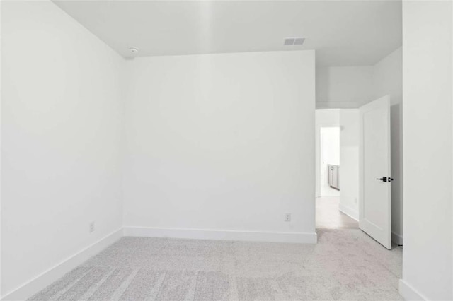 unfurnished room with light carpet, visible vents, and baseboards