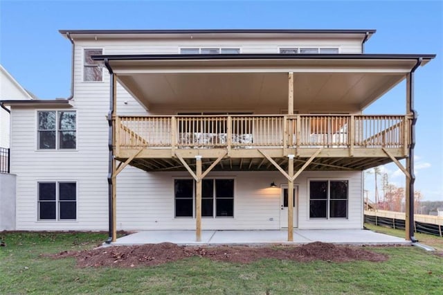 rear view of house with a patio area, a deck, fence, and a lawn