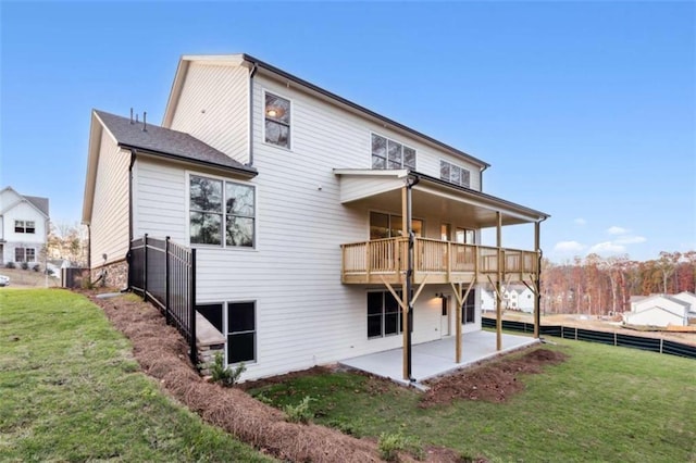 rear view of property featuring a patio area, a balcony, a yard, and fence