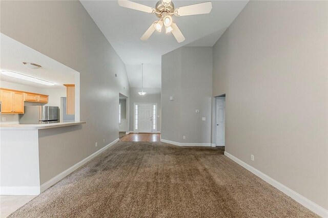 51 Legend Creek Way, Douglasville, GA 30134 - unfurnished living room with high vaulted ceiling, baseboards, a ceiling fan, and carpet flooring