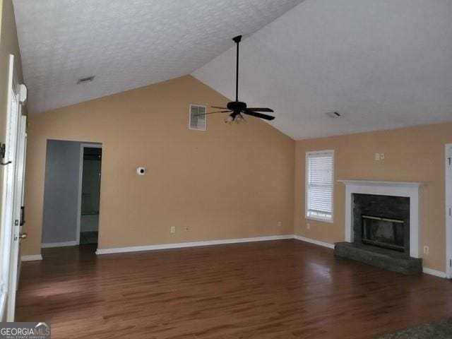 unfurnished living room featuring a glass covered fireplace, visible vents, ceiling fan, and wood finished floors