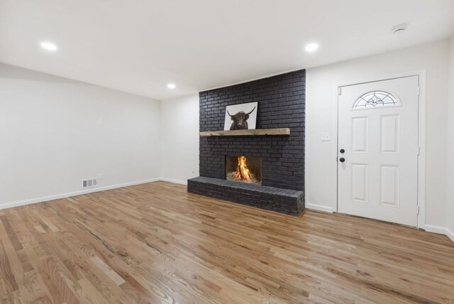 interior space with light wood-type flooring and a fireplace