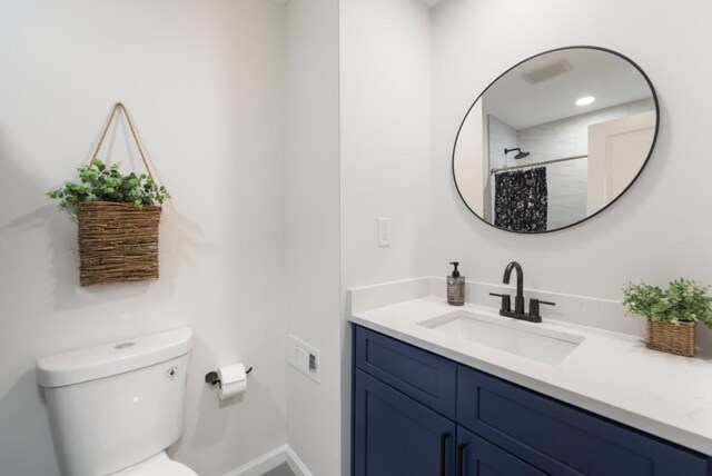 bathroom with toilet, vanity, and a shower with shower curtain