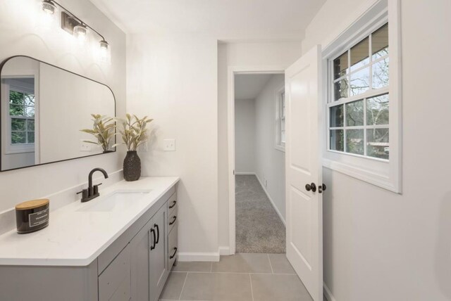 bathroom with tile patterned floors, vanity, and a healthy amount of sunlight