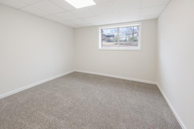 carpeted spare room featuring a paneled ceiling