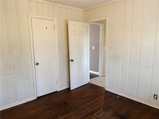 unfurnished bedroom with dark wood-style floors and crown molding