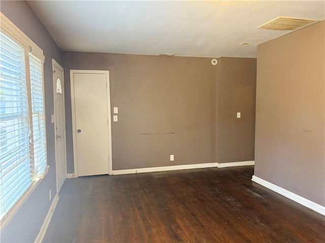 spare room with visible vents, baseboards, and wood finished floors