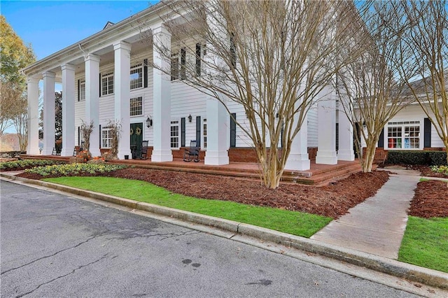 neoclassical / greek revival house featuring covered porch