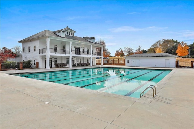 community pool with fence and a patio area