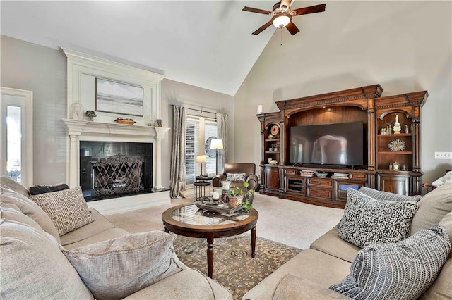 living room featuring ceiling fan, high vaulted ceiling, a premium fireplace, and carpet flooring
