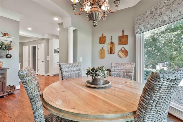 dining room with light wood finished floors, crown molding, recessed lighting, ornate columns, and a chandelier