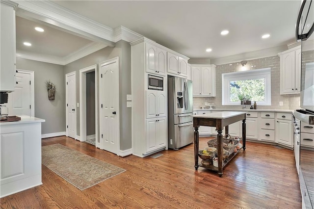 kitchen with stainless steel appliances, crown molding, backsplash, white cabinets, and recessed lighting