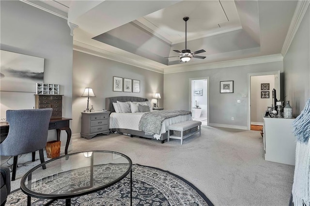 carpeted bedroom with crown molding, a raised ceiling, baseboards, connected bathroom, and ceiling fan