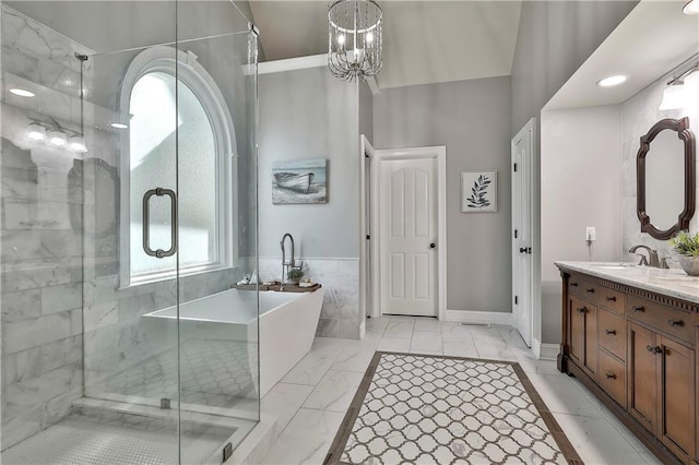 full bath with marble finish flooring, a shower stall, a soaking tub, double vanity, and a chandelier