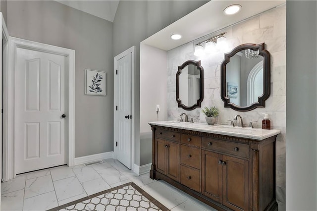 full bath featuring baseboards, marble finish flooring, recessed lighting, and double vanity