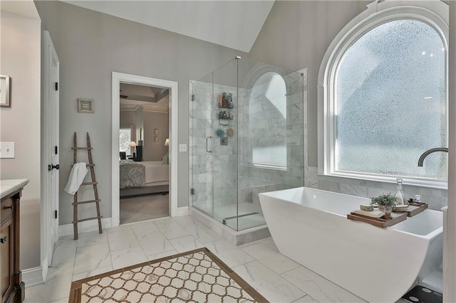 ensuite bathroom featuring marble finish floors, a shower stall, baseboards, a soaking tub, and vanity