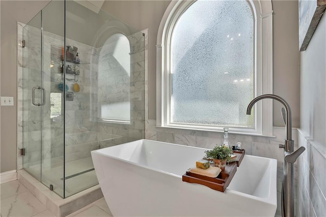 full bathroom featuring a shower stall and a freestanding tub