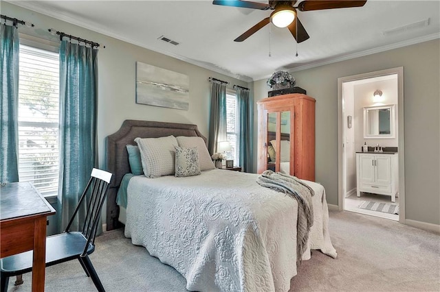 bedroom with light carpet, crown molding, ensuite bathroom, baseboards, and ceiling fan