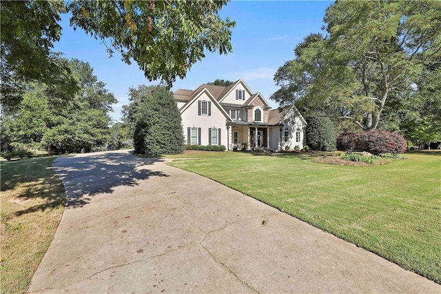 view of front of property featuring a front yard, driveway, and stucco siding