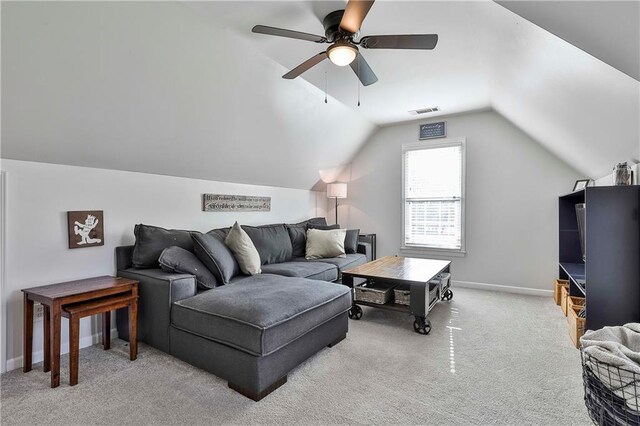 living area with light colored carpet, vaulted ceiling, ceiling fan, and baseboards