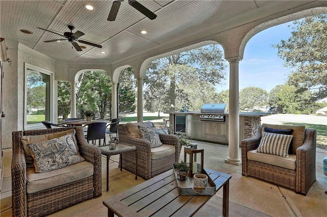view of patio with grilling area, an outdoor living space, a ceiling fan, and exterior kitchen
