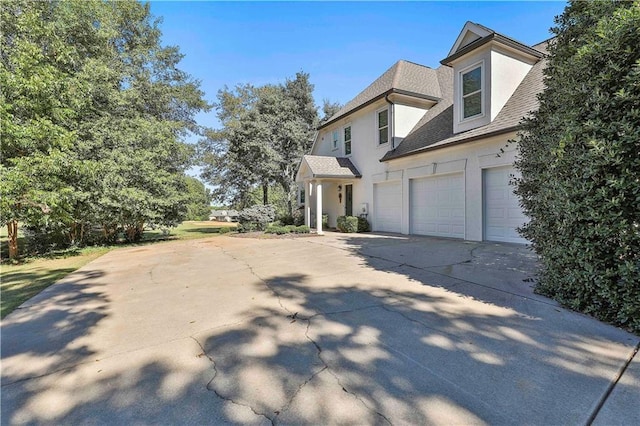 view of property exterior with stucco siding, concrete driveway, an attached garage, and roof with shingles