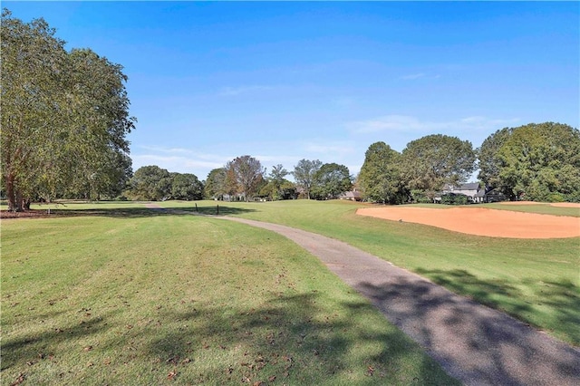 view of community with a yard, view of golf course, and view of scattered trees
