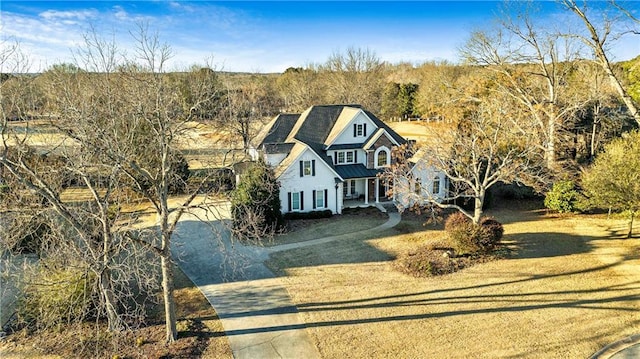 view of front of property with driveway, a standing seam roof, metal roof, and a front lawn