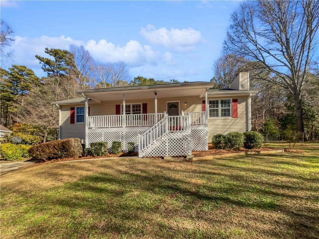 ranch-style house with covered porch and a front lawn