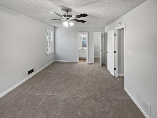 carpeted spare room featuring ceiling fan and a textured ceiling