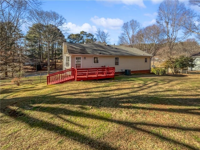 rear view of house with cooling unit, a wooden deck, and a yard