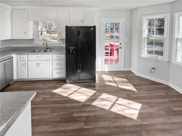 kitchen with dark wood-type flooring, sink, black fridge, dishwasher, and white cabinets