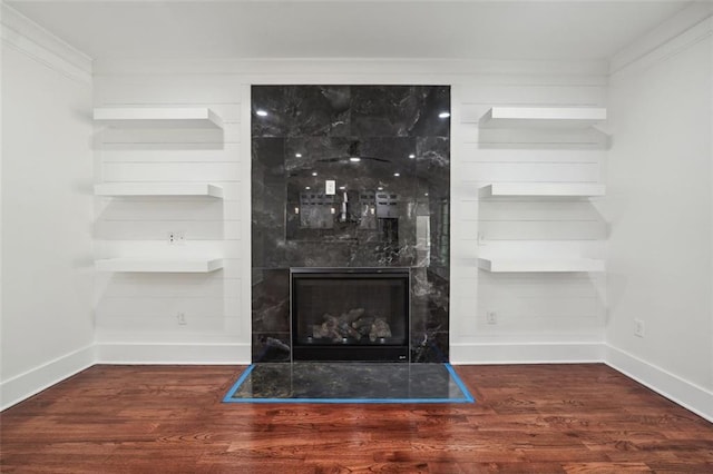 details featuring ornamental molding, a fireplace, built in features, and wood-type flooring