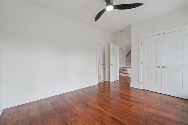 unfurnished bedroom with ceiling fan, dark hardwood / wood-style flooring, and a closet