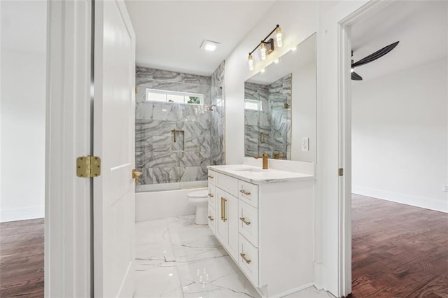 full bathroom featuring tiled shower / bath combo, vanity, ceiling fan, and toilet