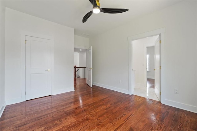 unfurnished bedroom featuring dark wood-type flooring and ceiling fan